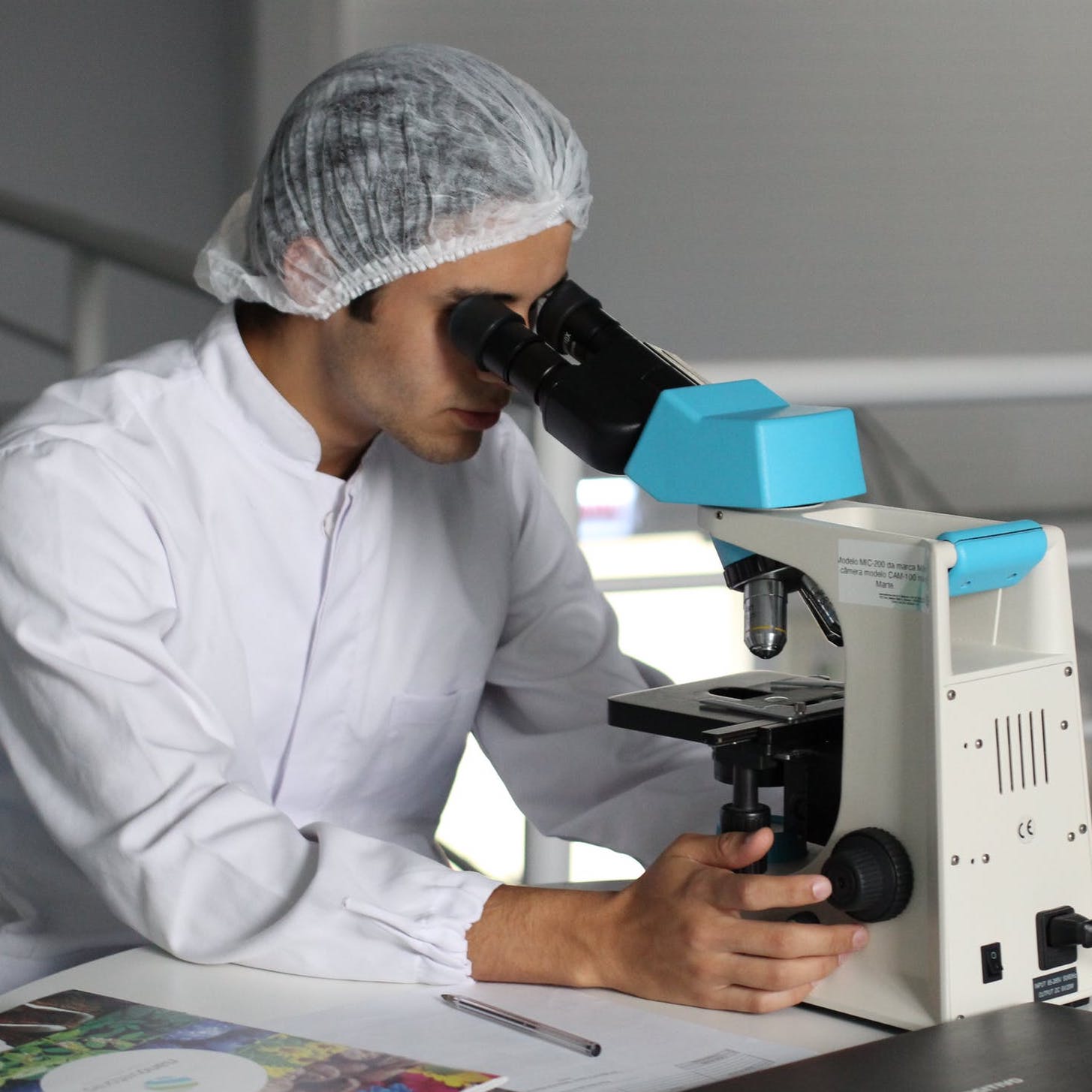 lab technician looking into microscope